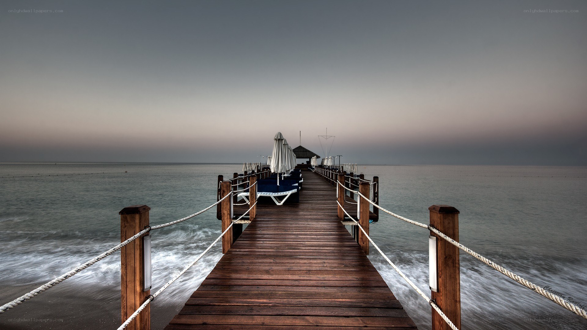 Pier at dusk with lounge chairs