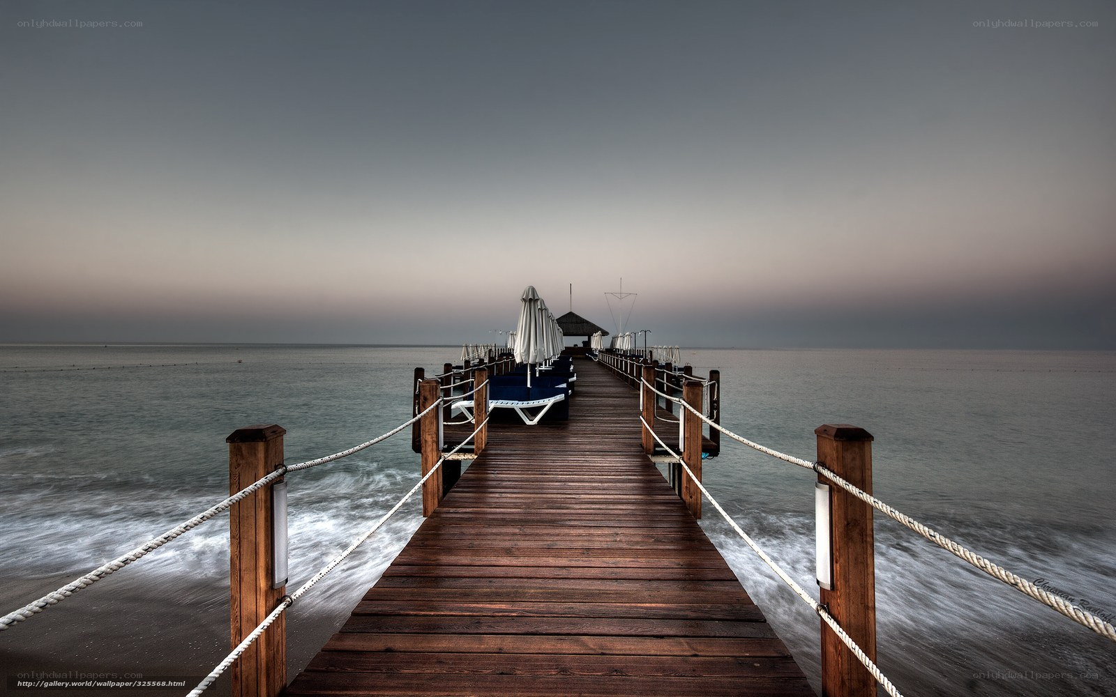 Pier at dusk with lounge chairs