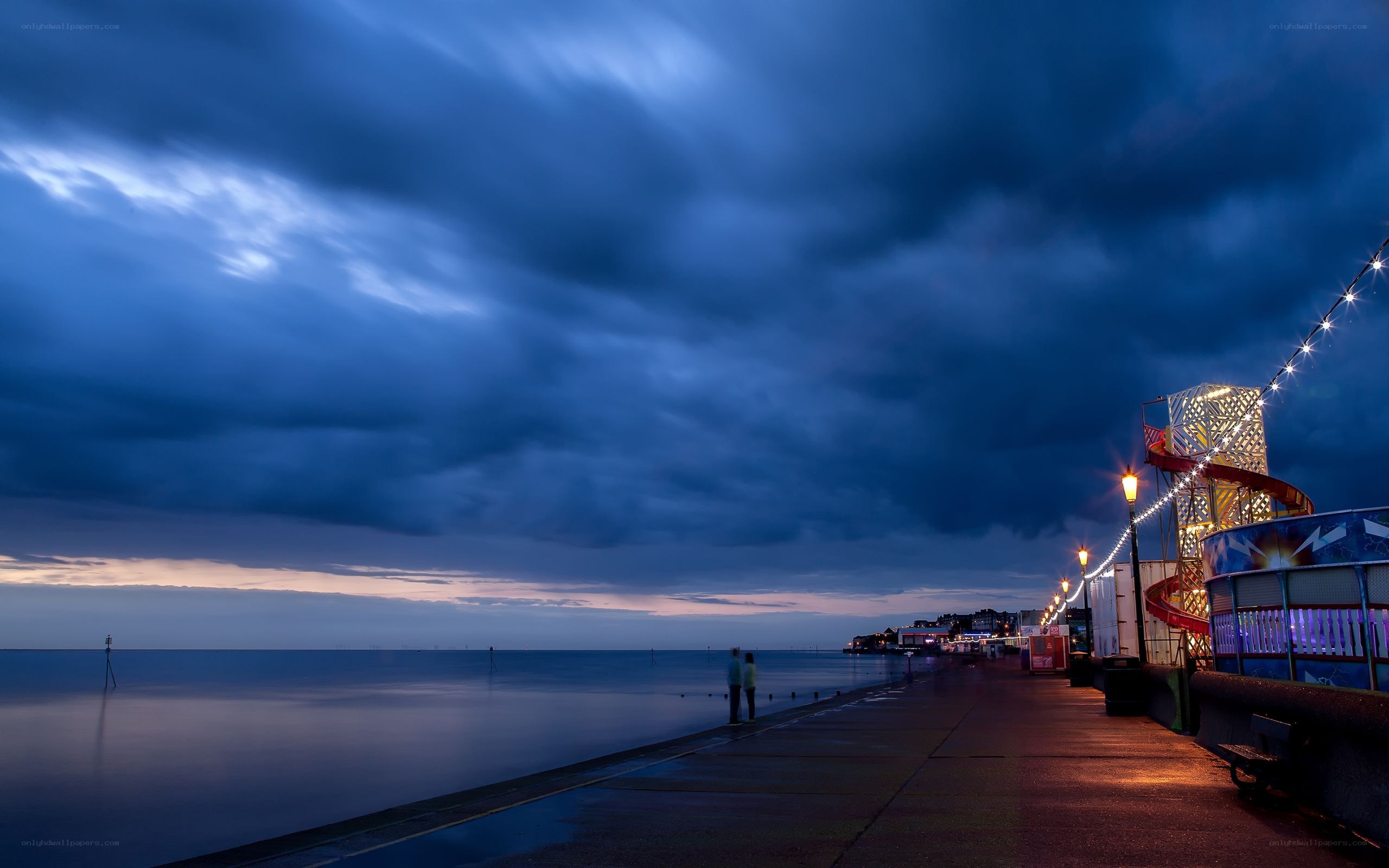 Pier at dusk with roller coaster