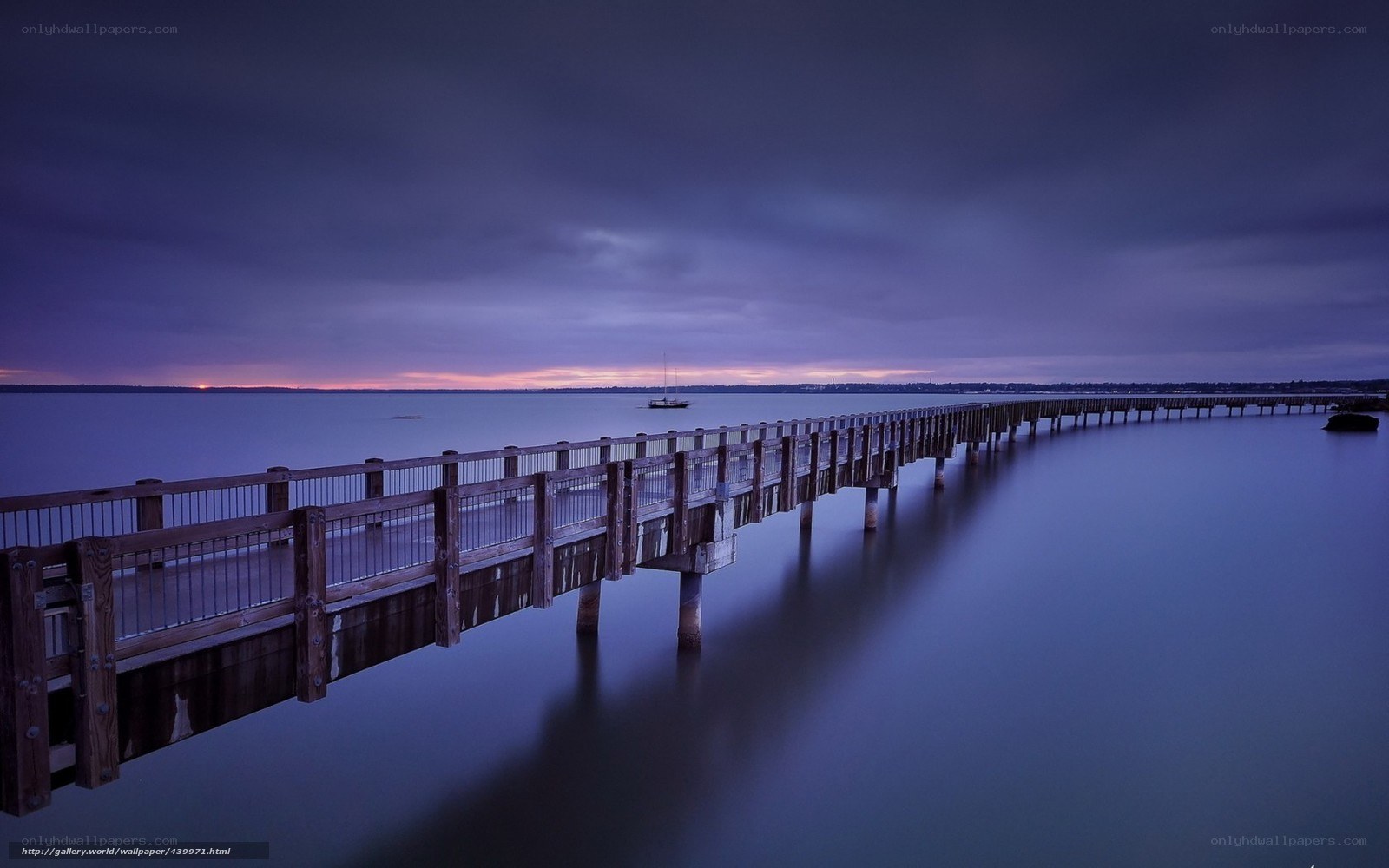 Pier at dusk with sailboat