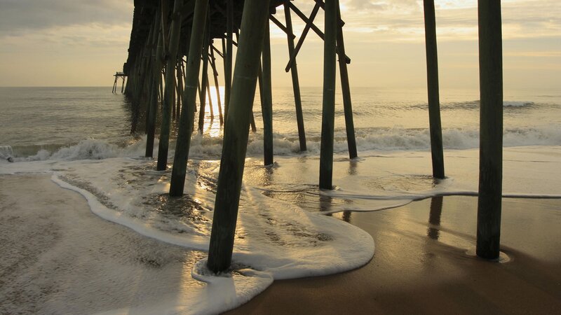 Pier at sunrise with waves