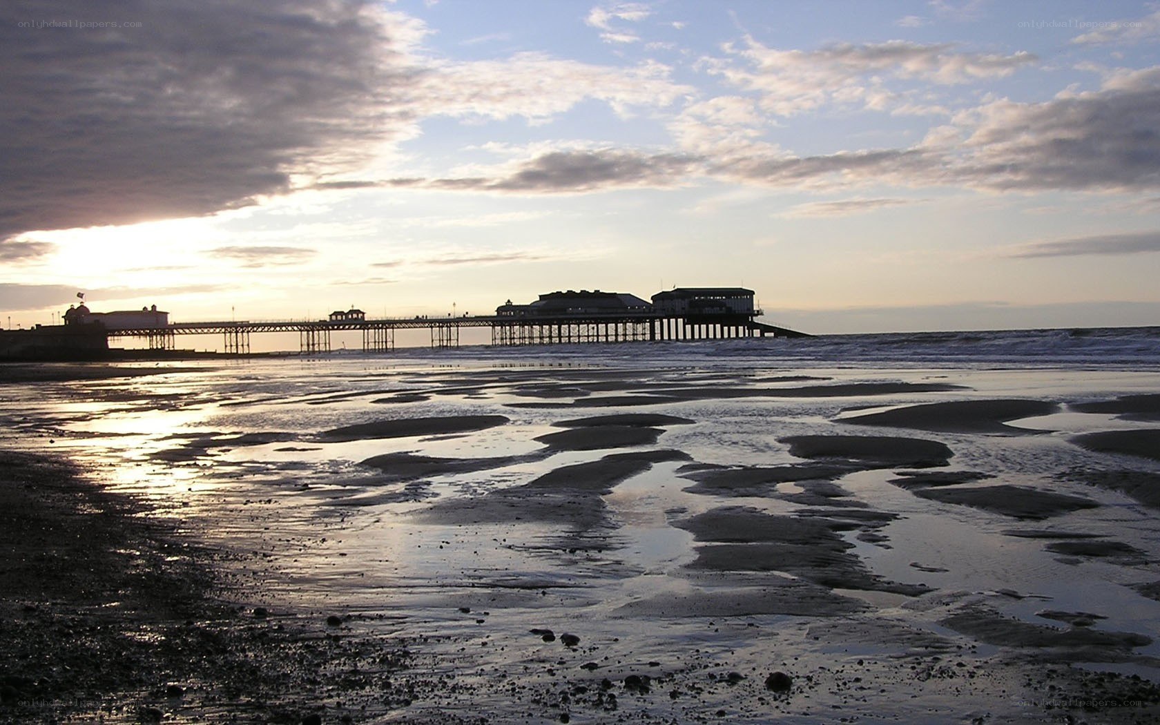 Pier at sunset on a beach