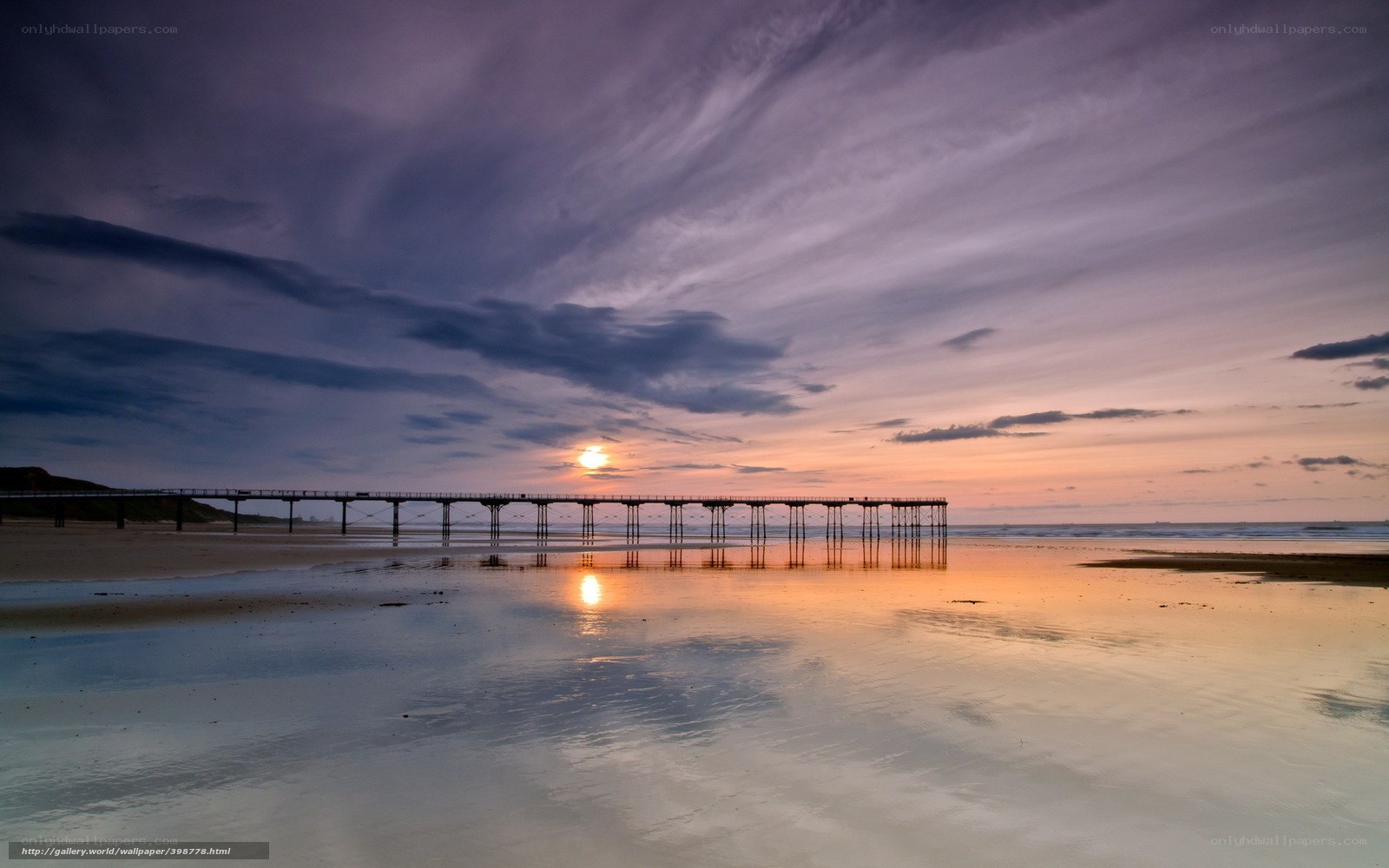Pier at sunset on a calm beach