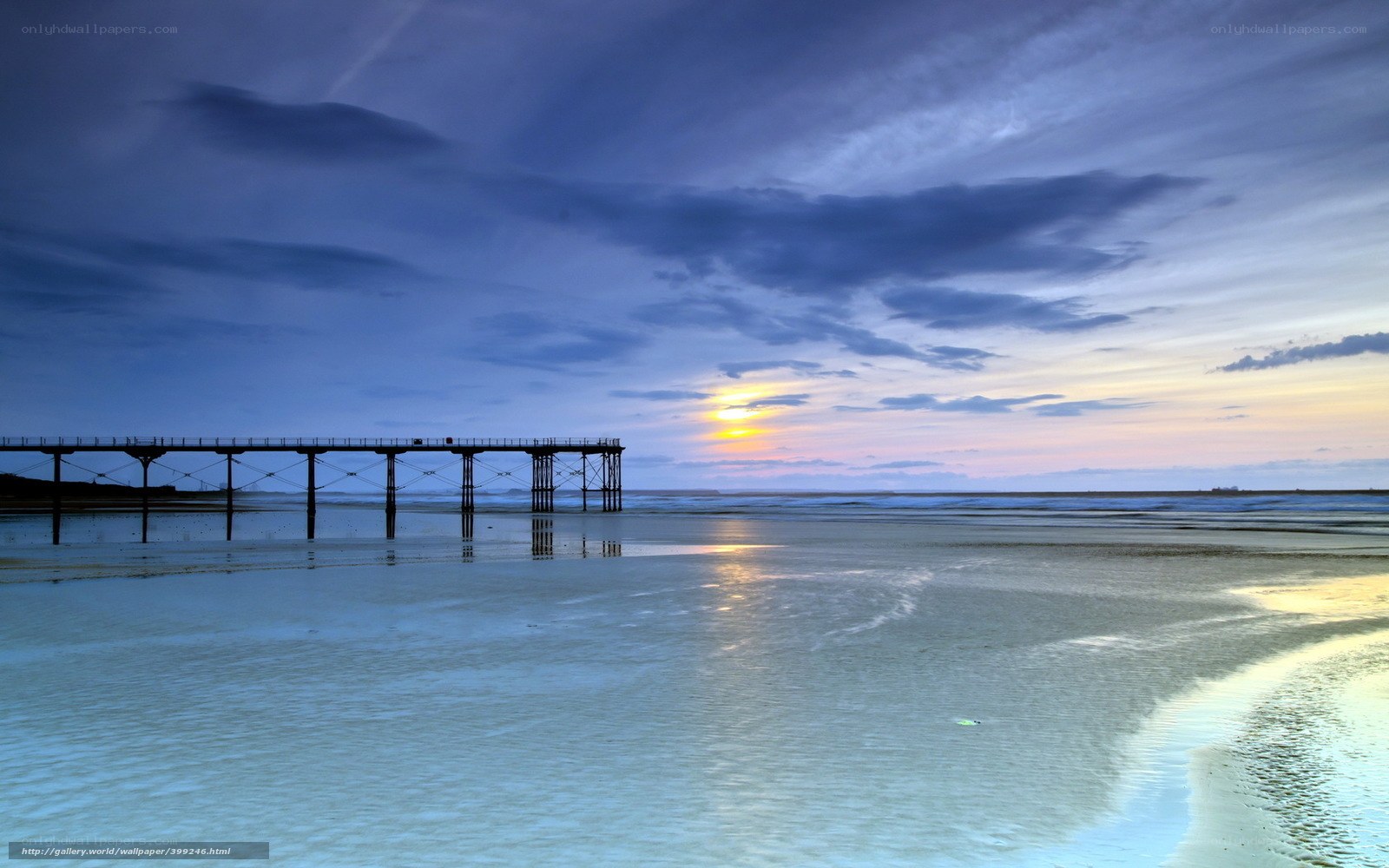 Pier at sunset on a calm beach