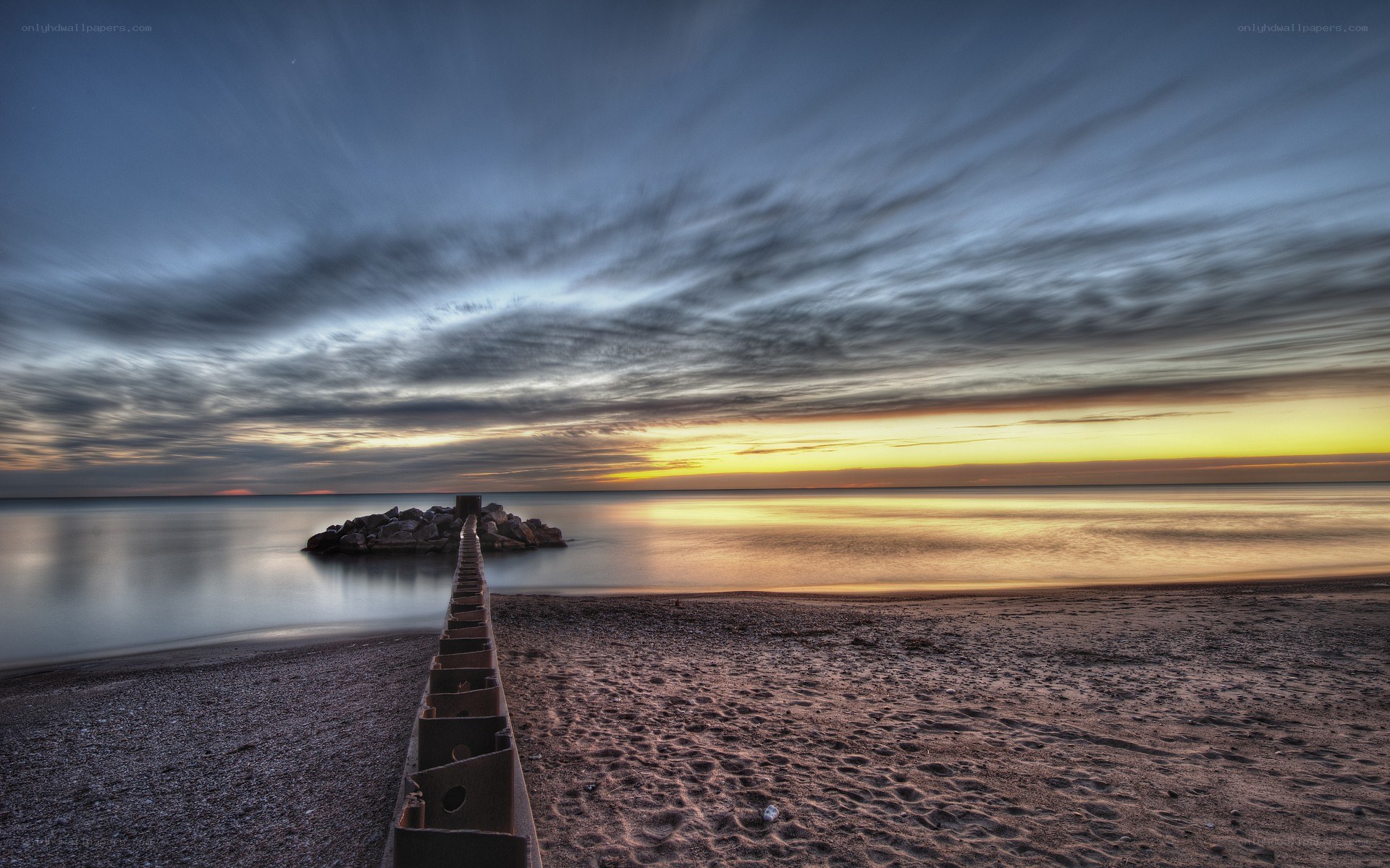 Pier at sunset on a calm beach