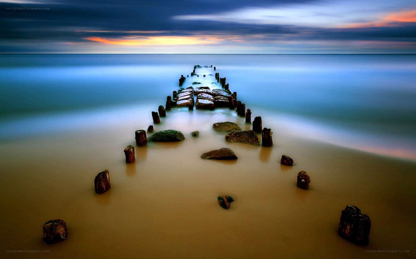 Pier at sunset on a calm beach