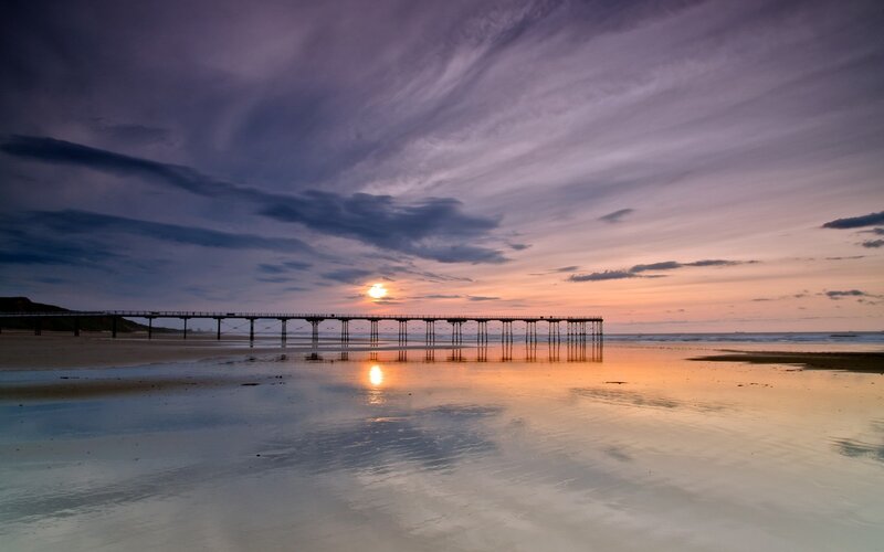 Pier at sunset on a calm beach