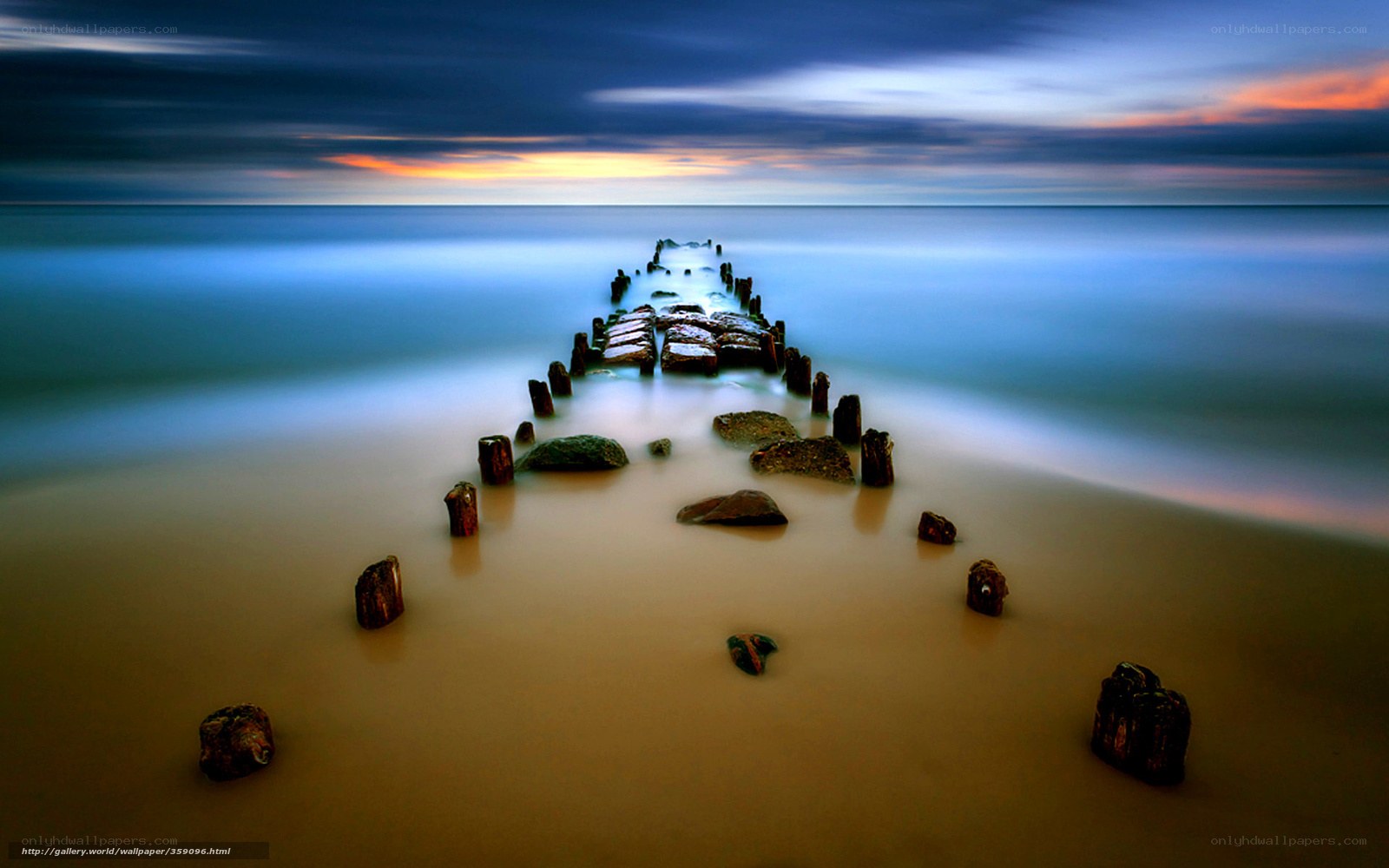 Pier at sunset on a calm beach