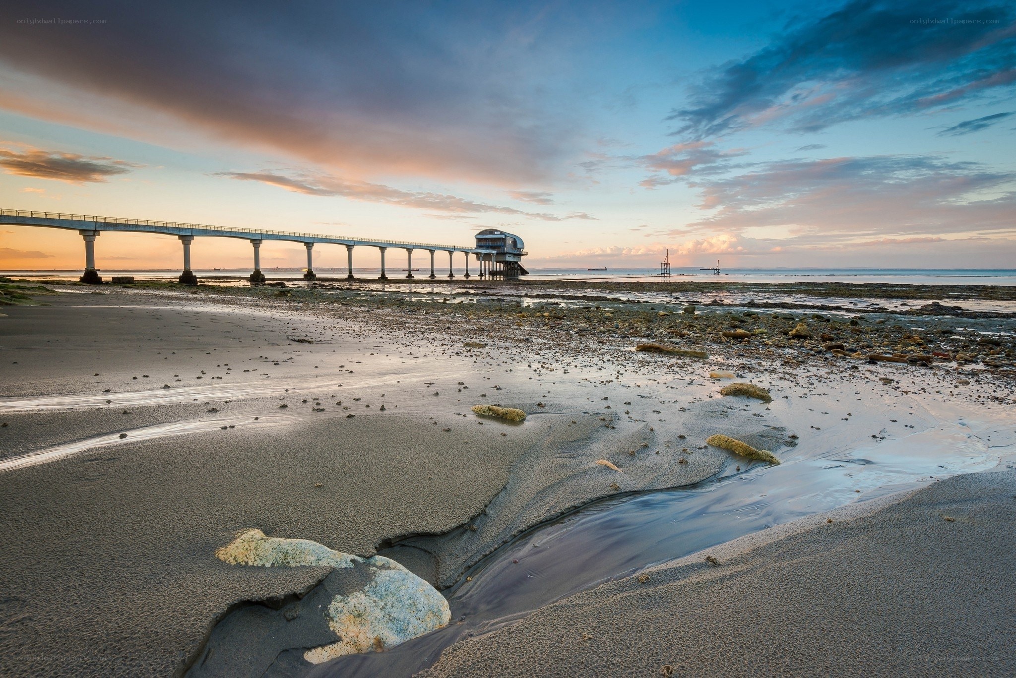 Pier at sunset on a sandy beach