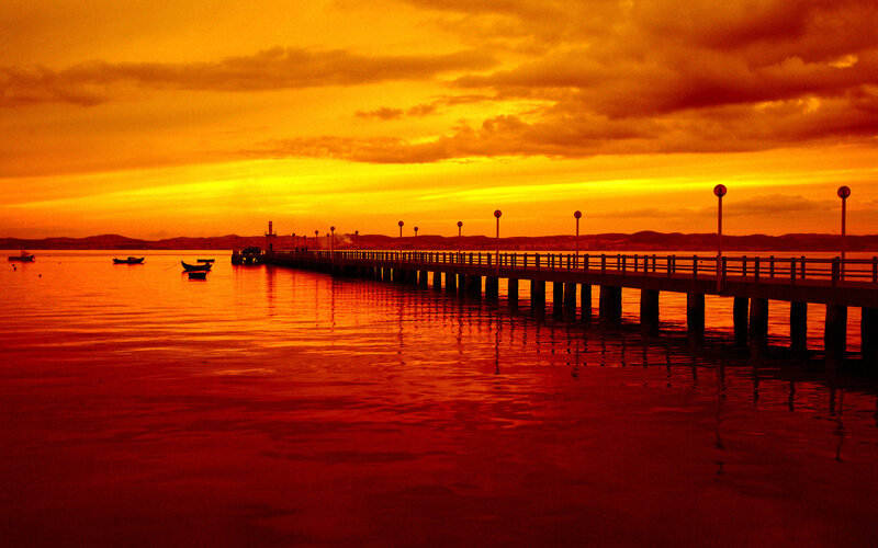 Pier at Sunset — Orange, Dramatic, Photograph, Boats, Lighthouse, Mountains