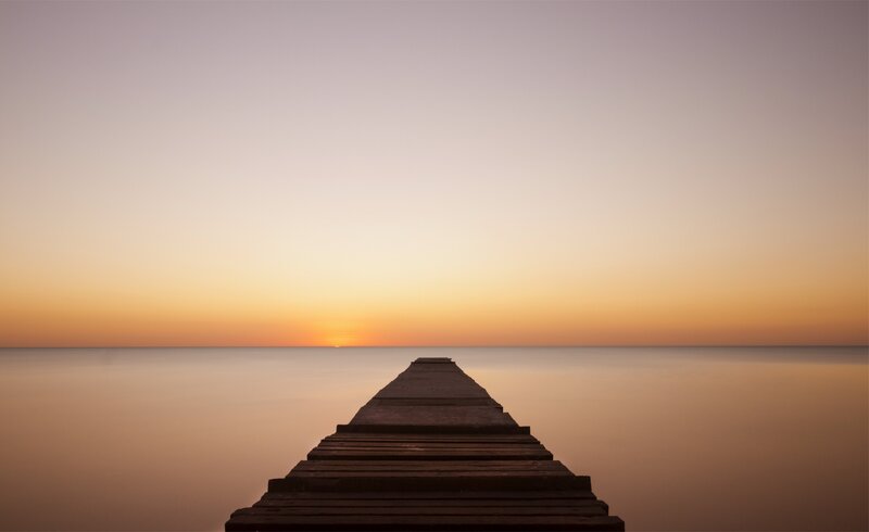 Pier at sunset over calm water