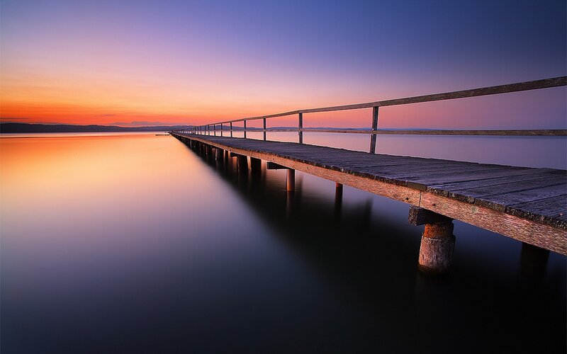 Pier at sunset over calm water