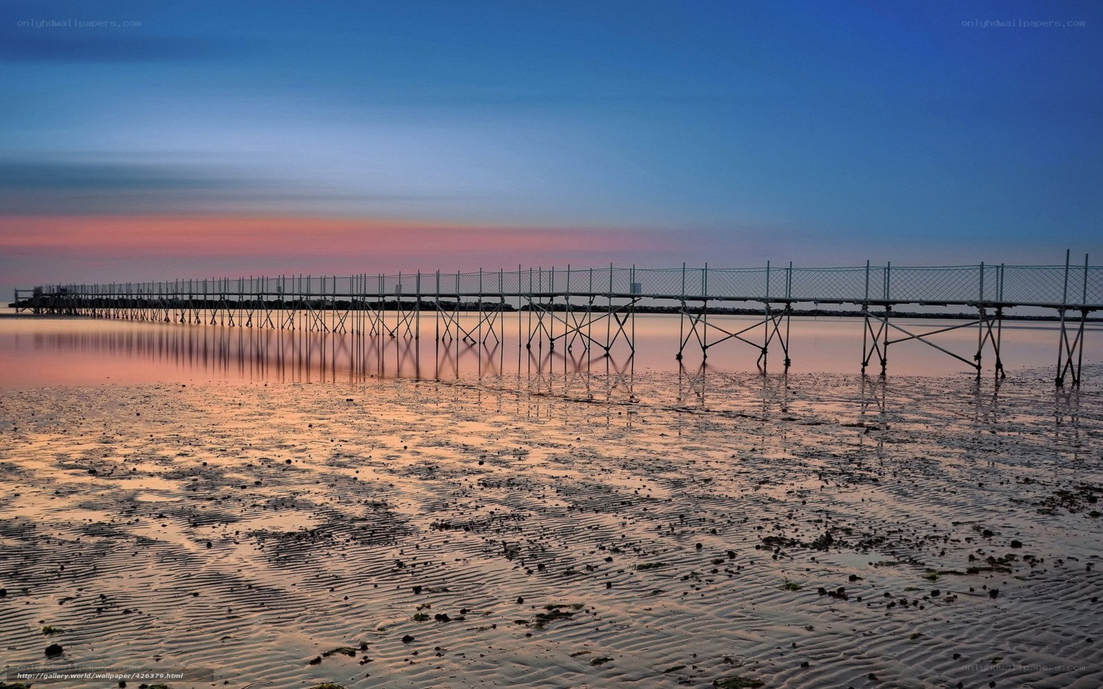 Pier at sunset over tidal flats