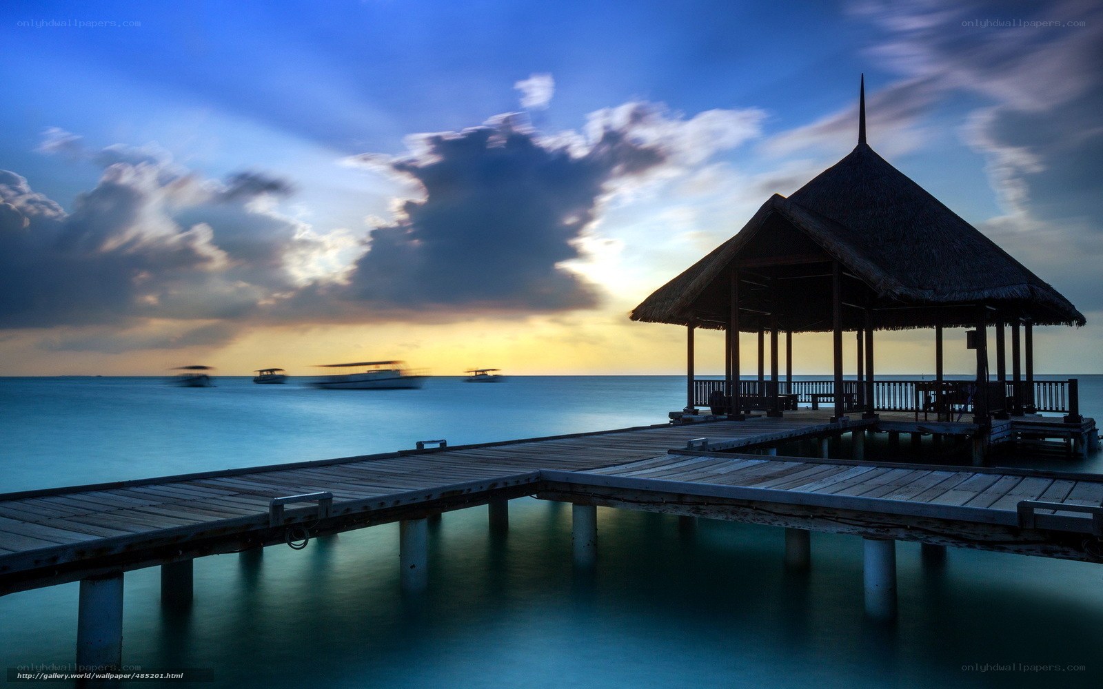 Pier at sunset with boats