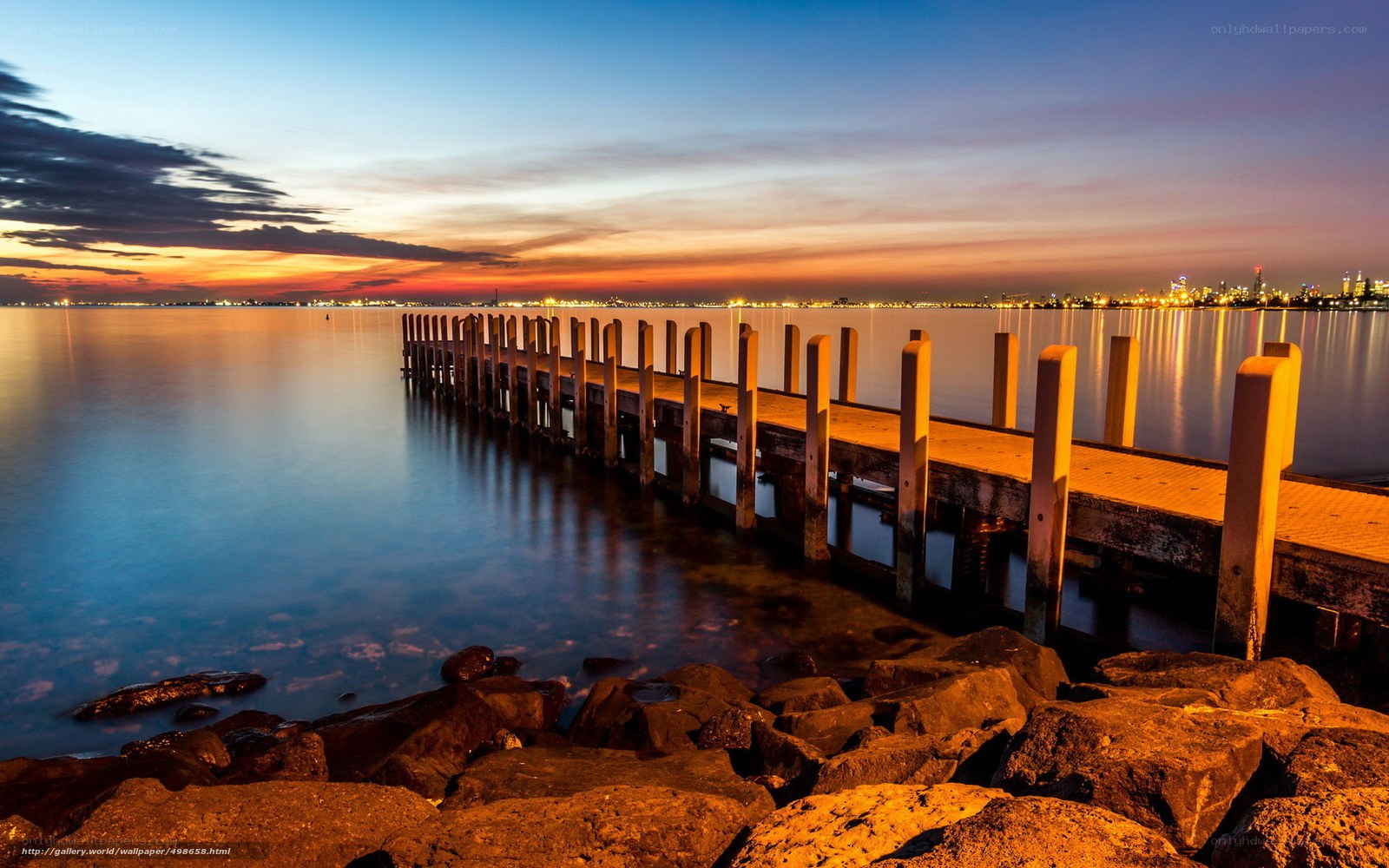 Pier at sunset with city lights