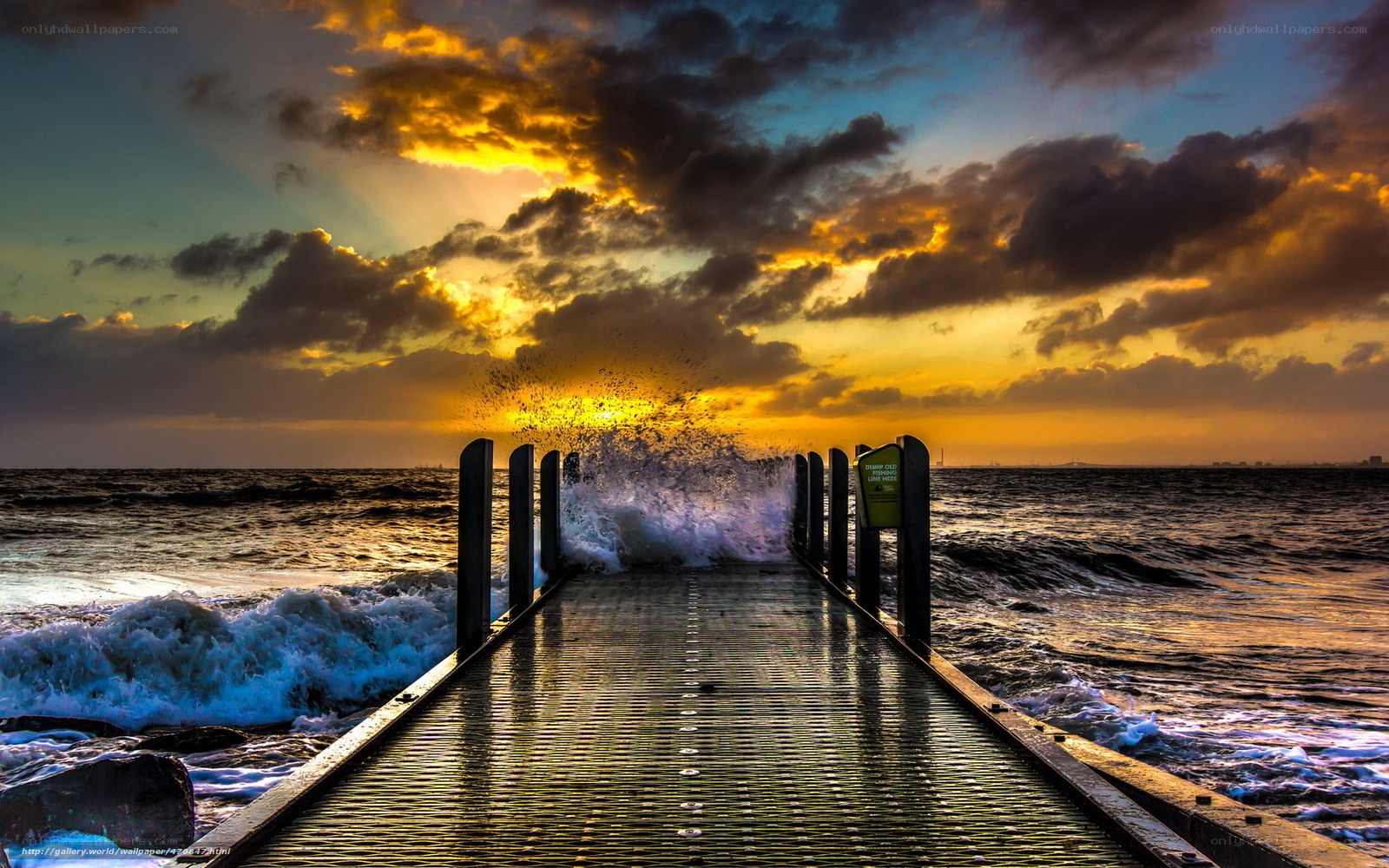 Pier at sunset with crashing waves