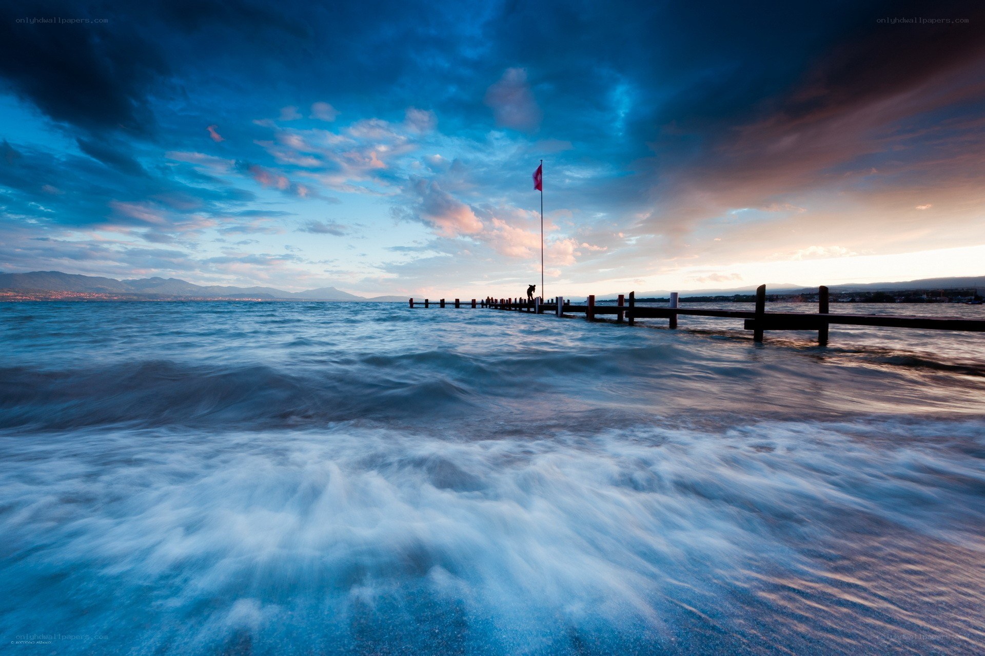 Pier at sunset with flag
