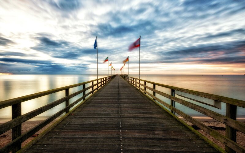 Pier at sunset with flags