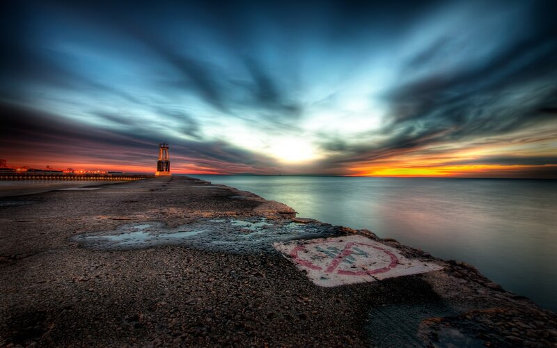 Pier at sunset with lighthouse