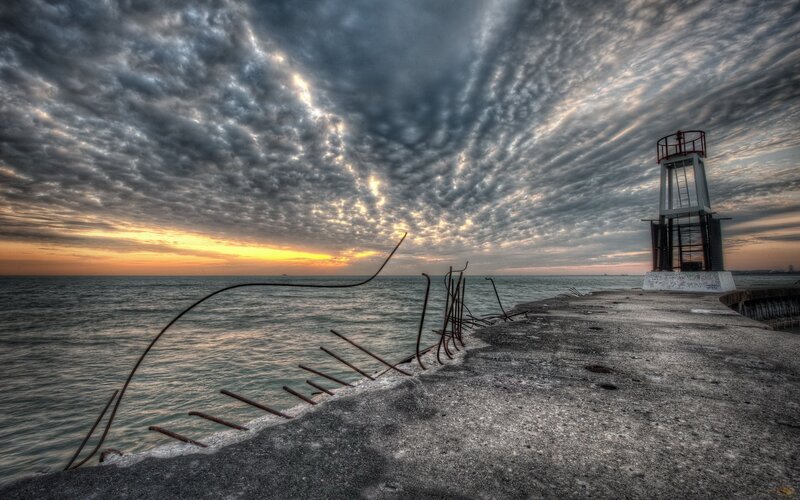 Pier at sunset with lighthouse