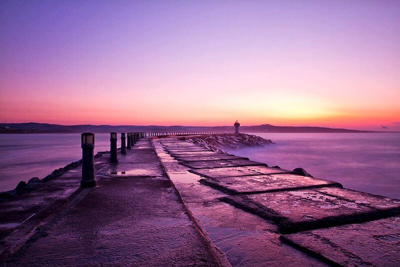 Pier at sunset with lighthouse