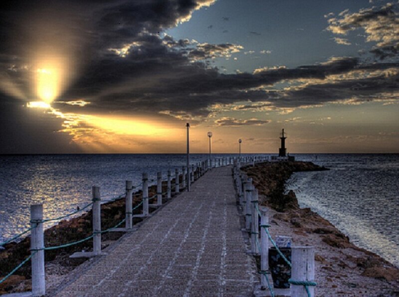 Pier at sunset with lighthouse