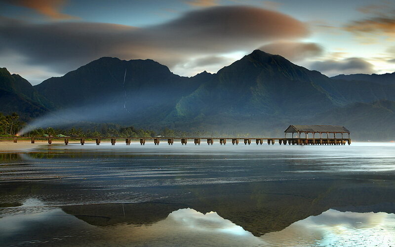 Pier at sunset with mountain reflection
