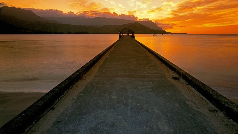 Pier at sunset with mountains