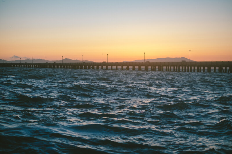 Pier at sunset with ocean waves