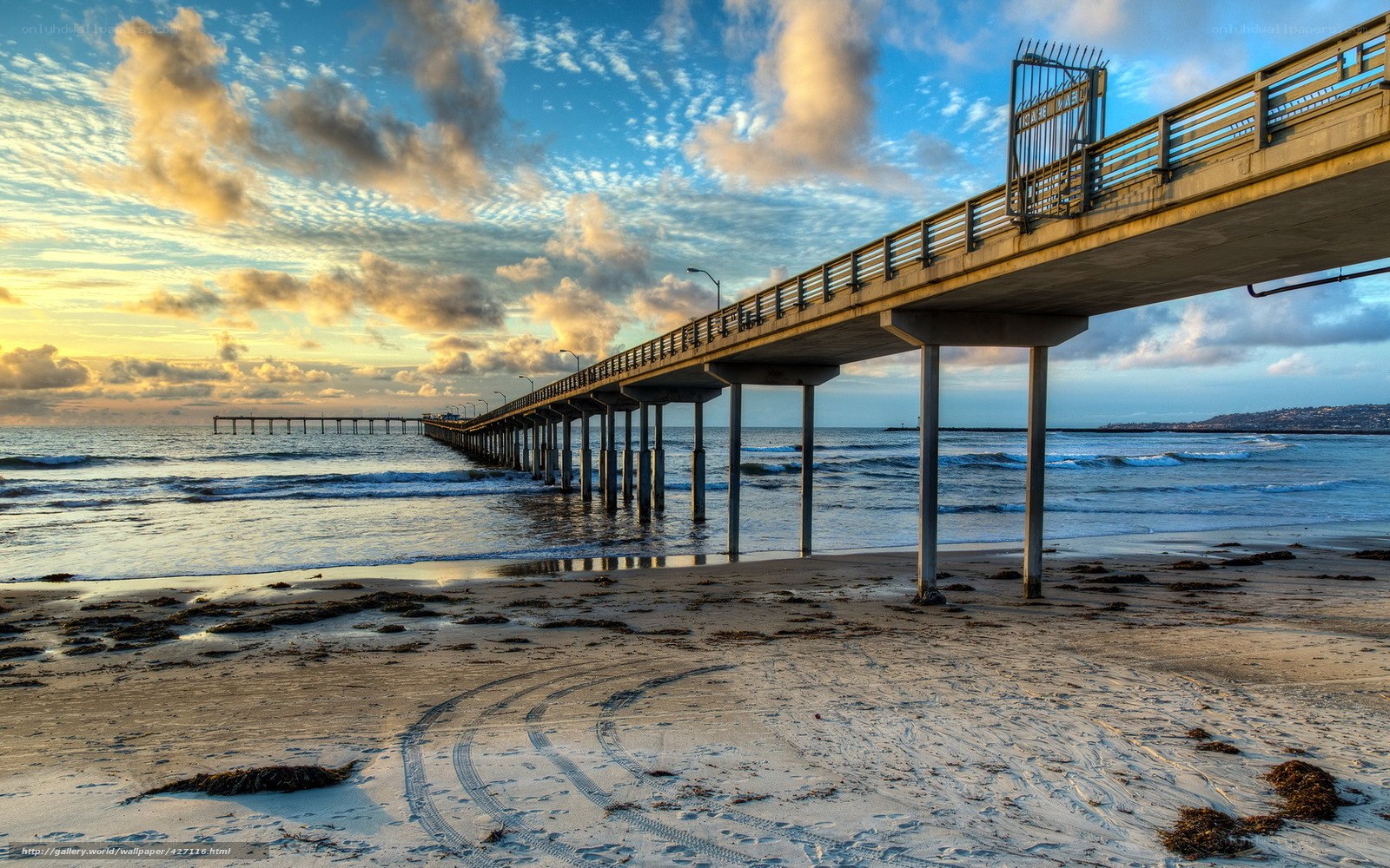 Pier at sunset with ocean waves
