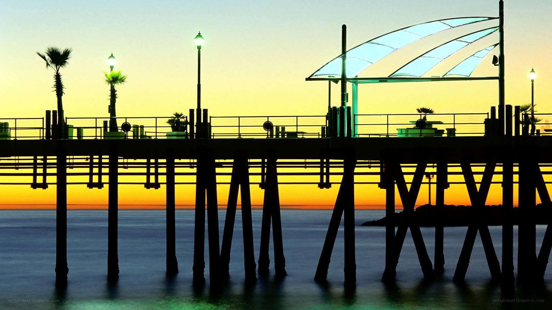 Pier at sunset with palm trees