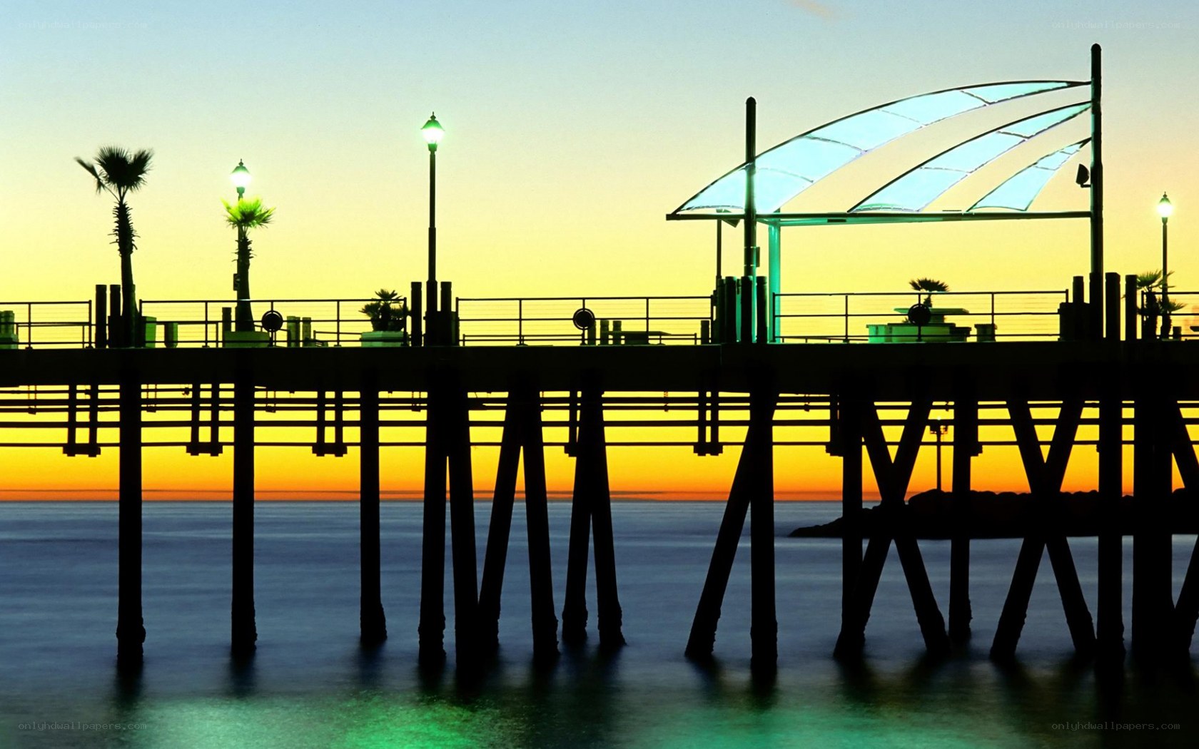 Pier at sunset with palm trees