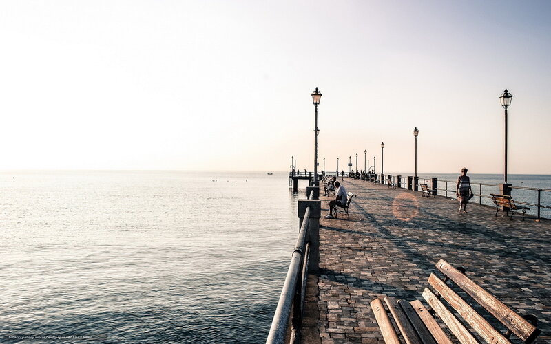 Pier at sunset with people