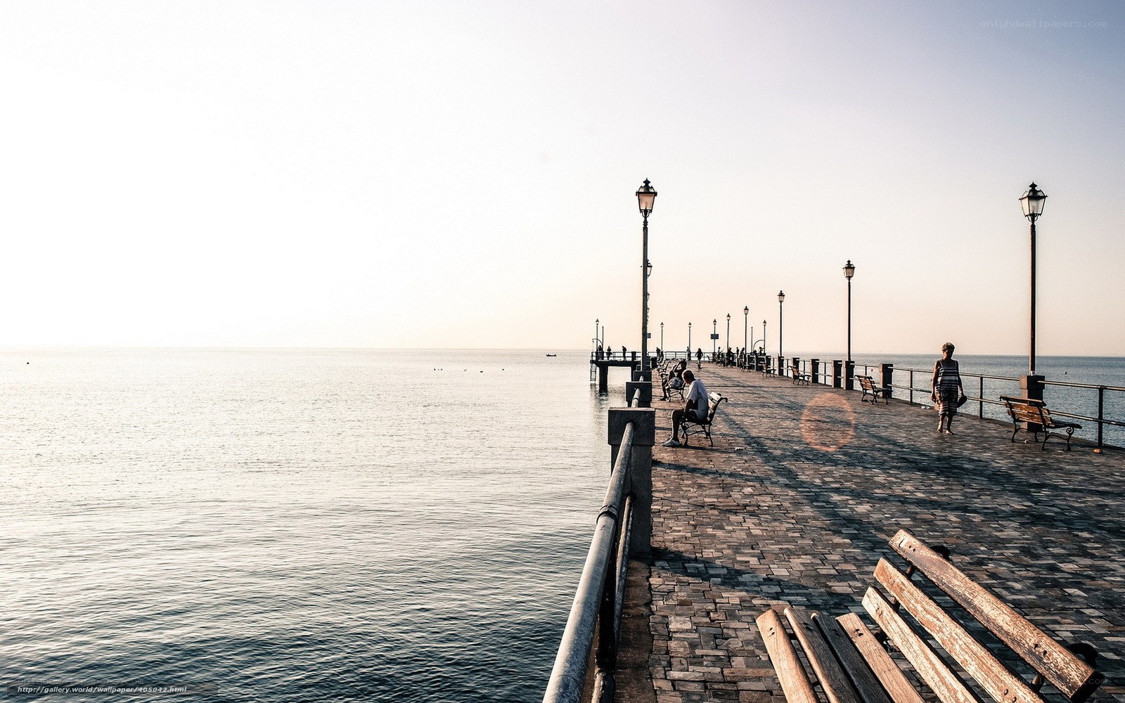 Pier at sunset with people