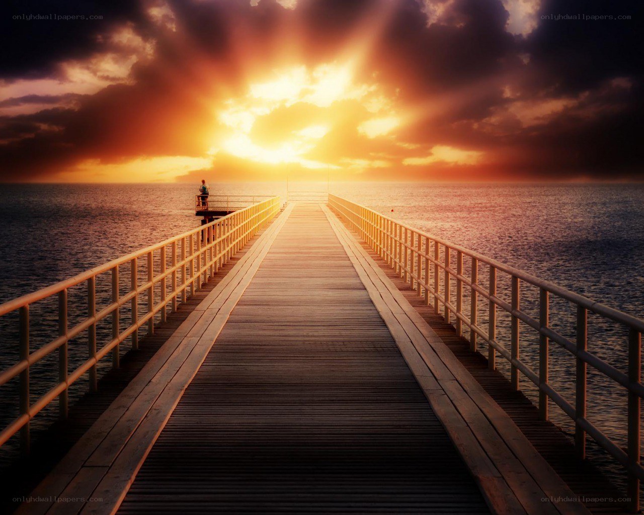 Pier at sunset with person