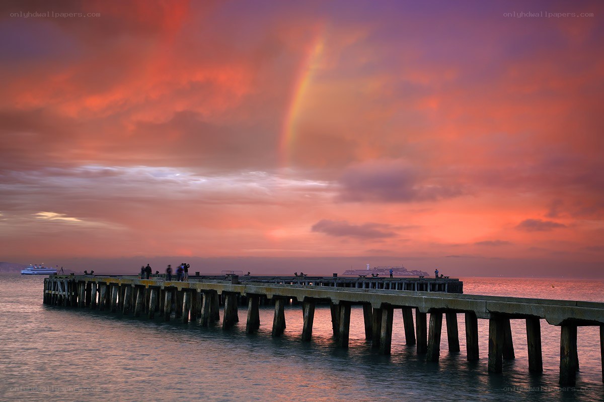 Pier at sunset with rainbow