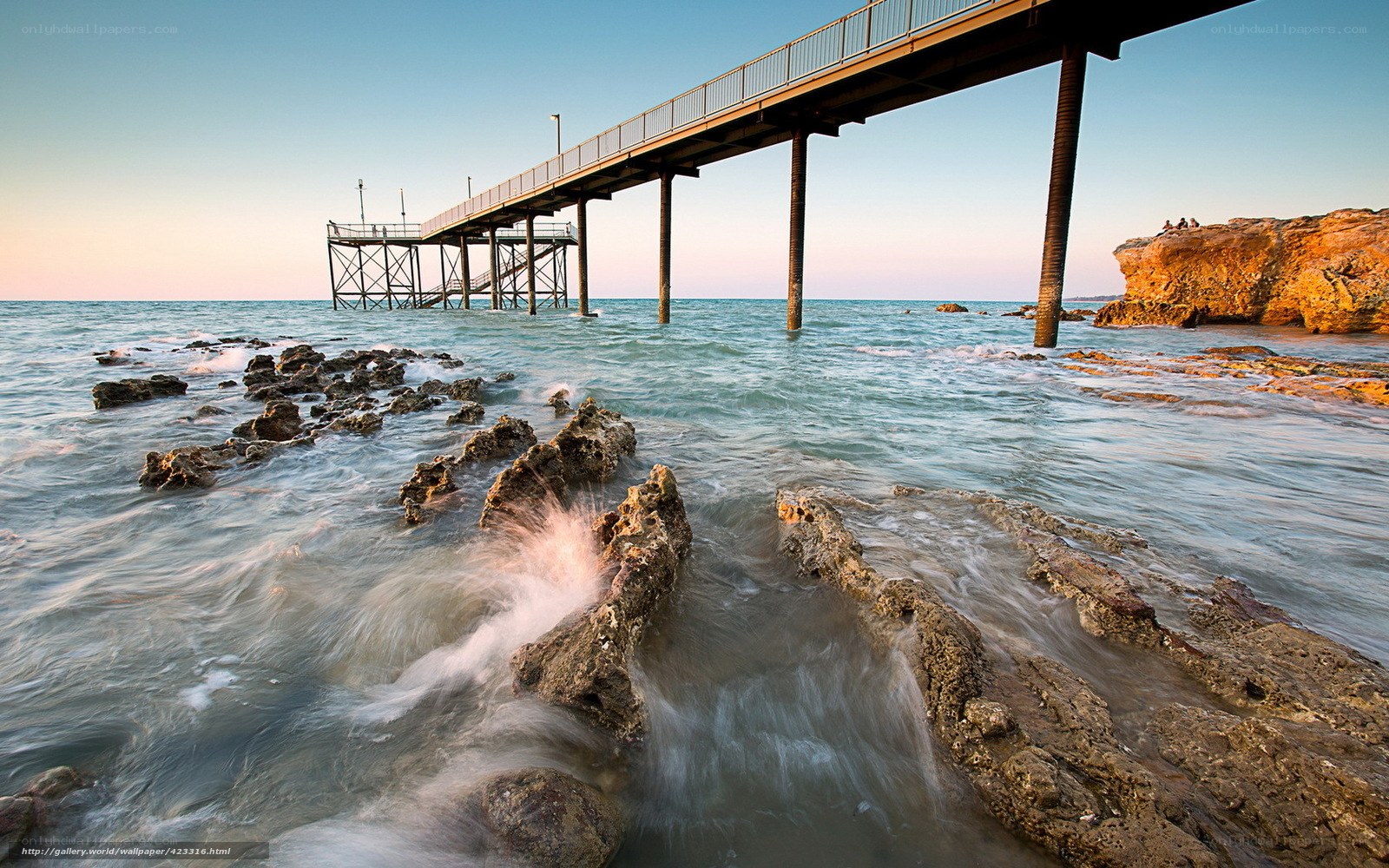 Pier at sunset with rocky shore