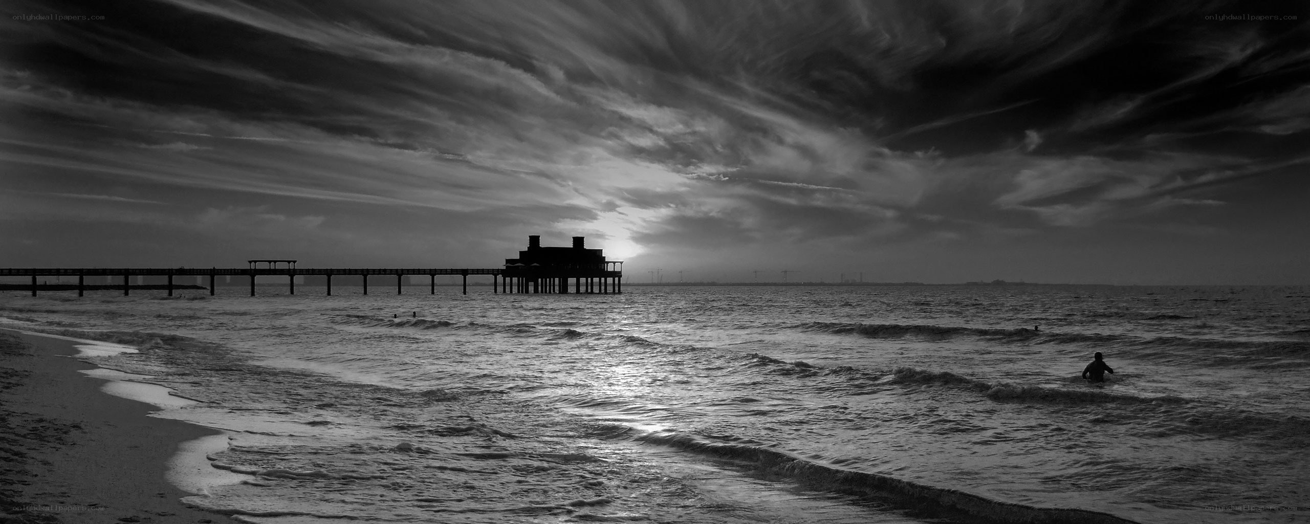 Pier at sunset with swimmer