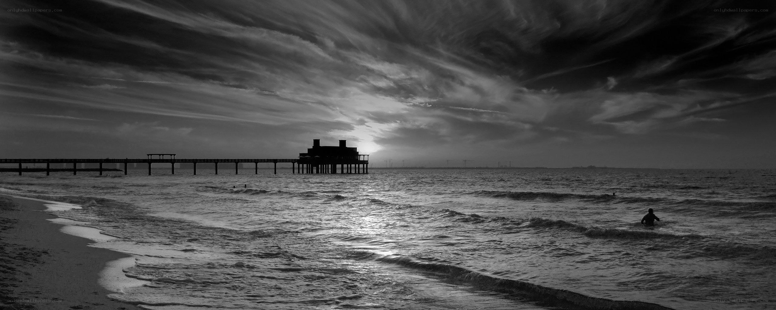Pier at sunset with swimmer