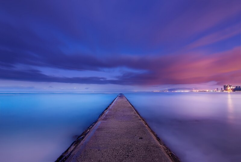 Pier at twilight with city lights