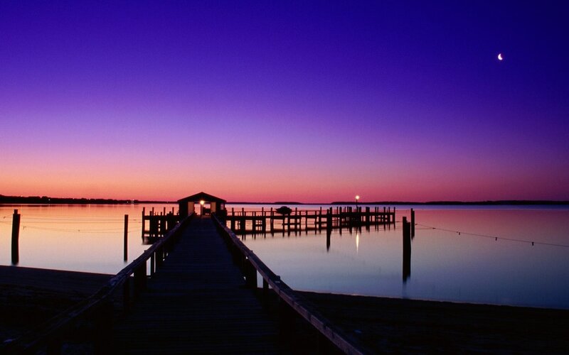 Pier at twilight with crescent moon