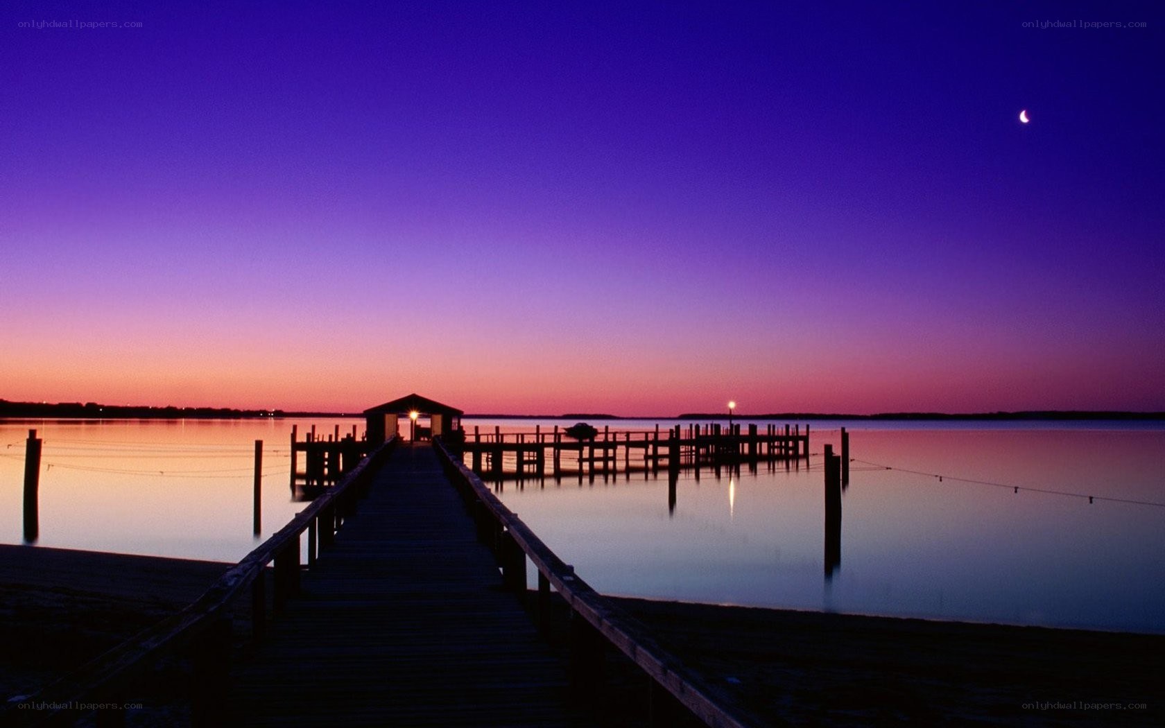 Pier at twilight with crescent moon