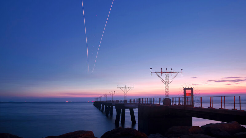 Pier at twilight with light trails