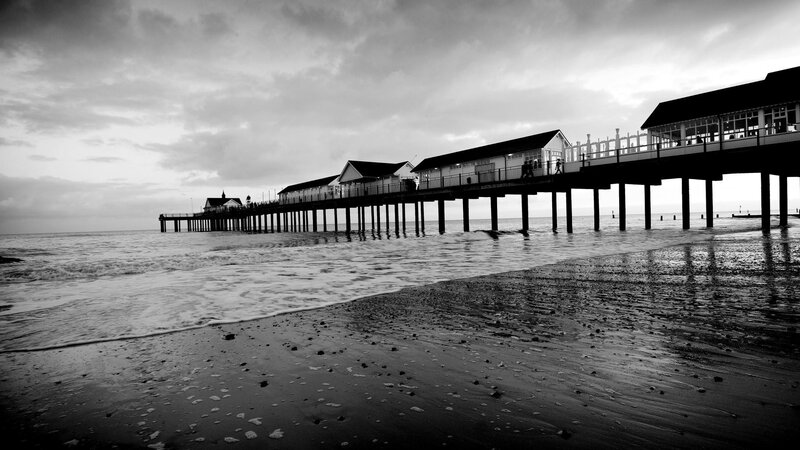Pier Extending into Ocean — Black, Dramatic