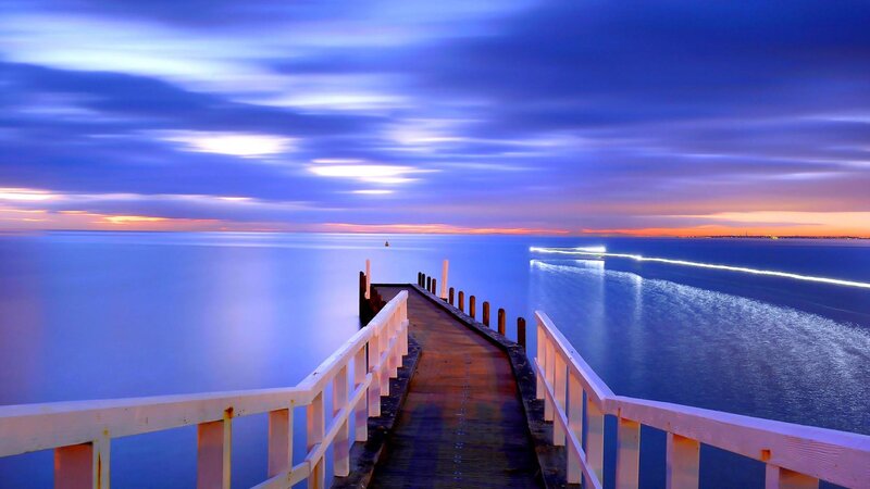 Pier Extending into Ocean — Blue, Serene, Sunset, Photograph, Sky