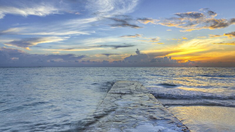 Pier Extending into Ocean — Blue, Serene, Sunset, Photograph