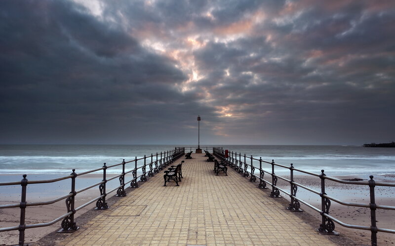 Pier Extending into Ocean — Gray