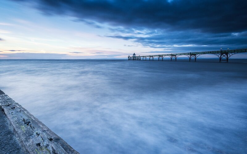 Pier Extending into Sea — Blue, Serene, Sunset, Photograph