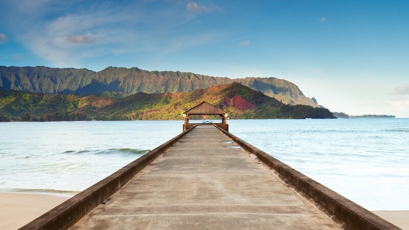 Pier leading to mountainous coast