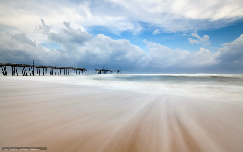 Pier on a cloudy beach